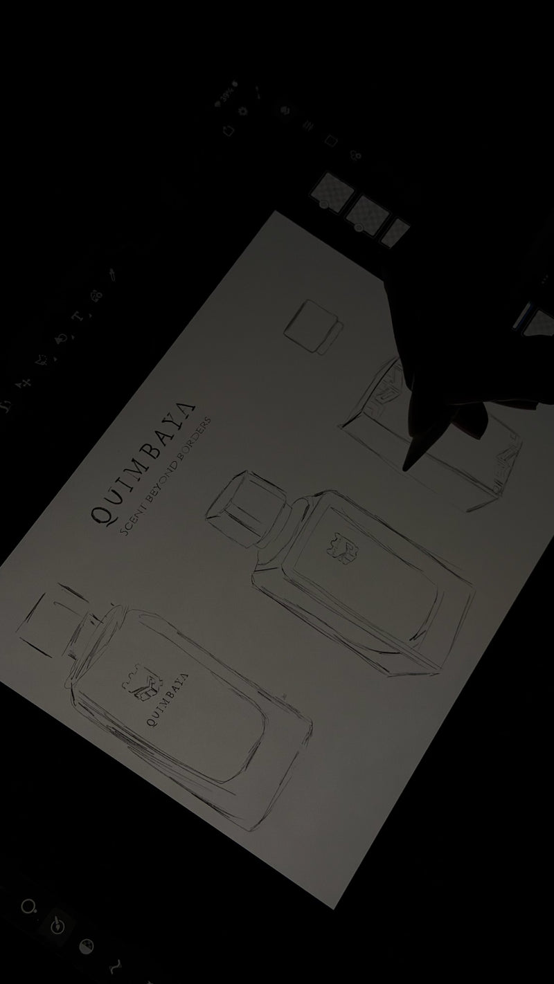 A black tablet or digital drawing screen showing a white sketch pad with faint perfume bottle line drawings and the word 'QUIMBAYA'. A black hand holding a stylus is visible in the upper right, against a very dark background.