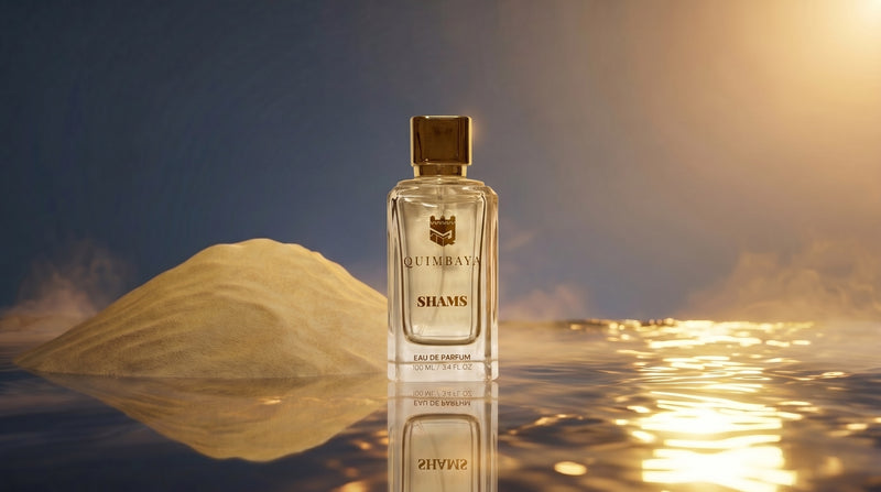 A bottle of Shams by Quimbaya Niche Perfume stands centred on a reflective surface with a warm golden mountain and misty sky in the background